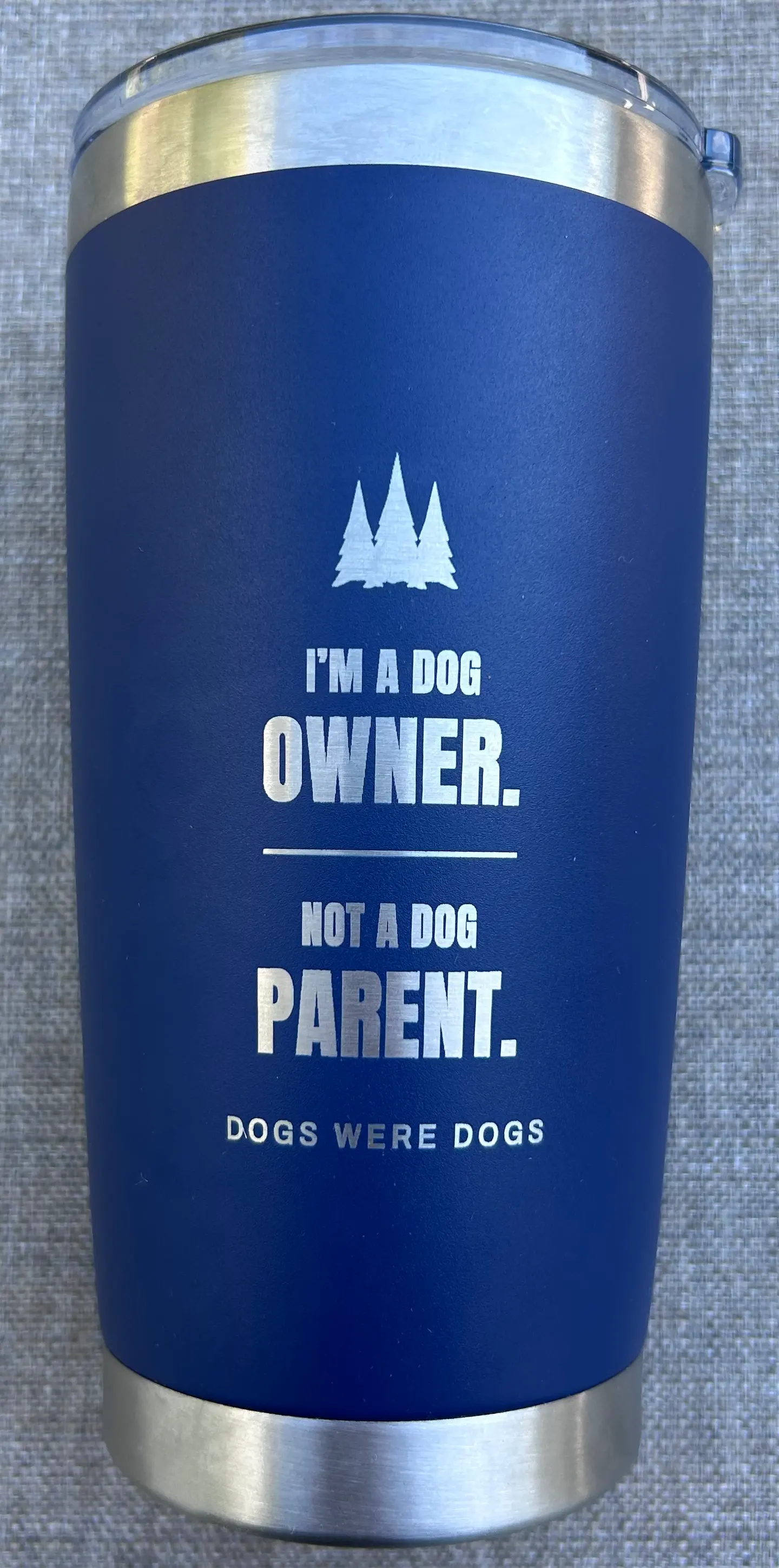 Dog Owner Tumbler shown back-side, laser-engraved with the lines I'M A DOG OWNER. NOT A DOG PARENT. in a condensed display face, with the small DOGS WERE DOGS signature beneath.